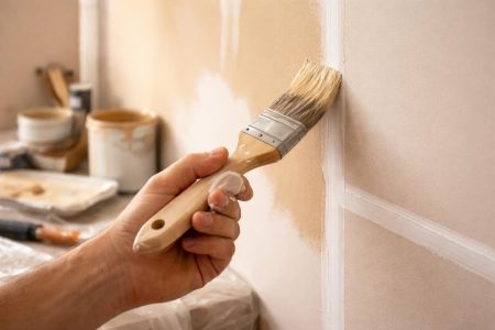 main-pinceau-mur-peint-outils